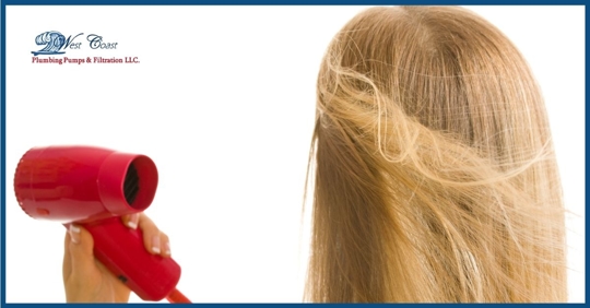 A woman blow drying her hair.